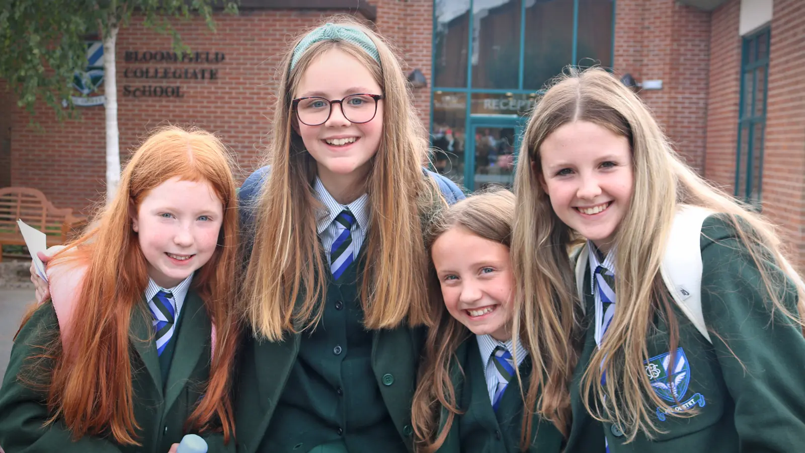 pupils posing in front of school