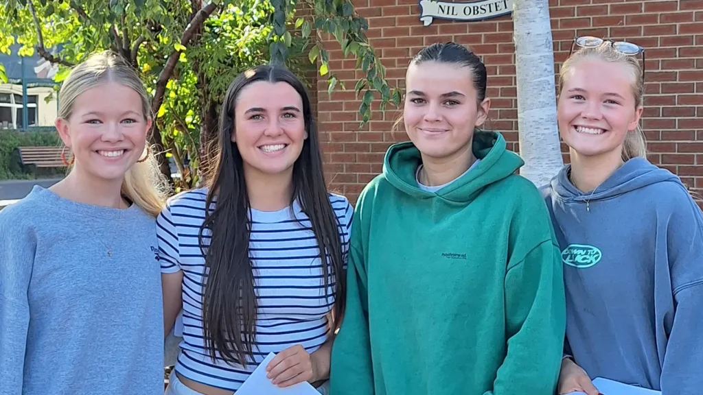 pupils posing in front of school